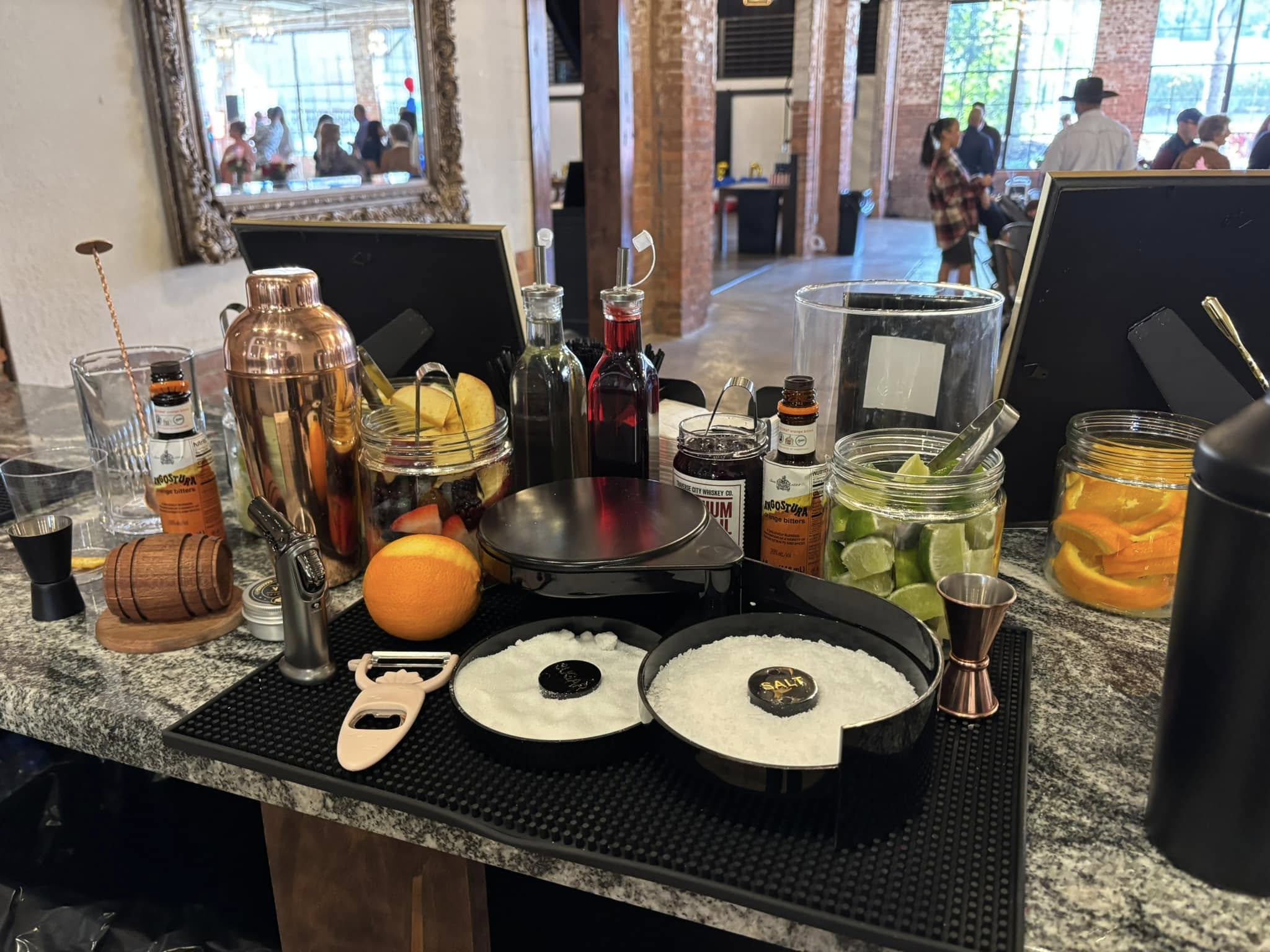 Craft cocktail bar setup with shakers, citrus, and fresh garnishes