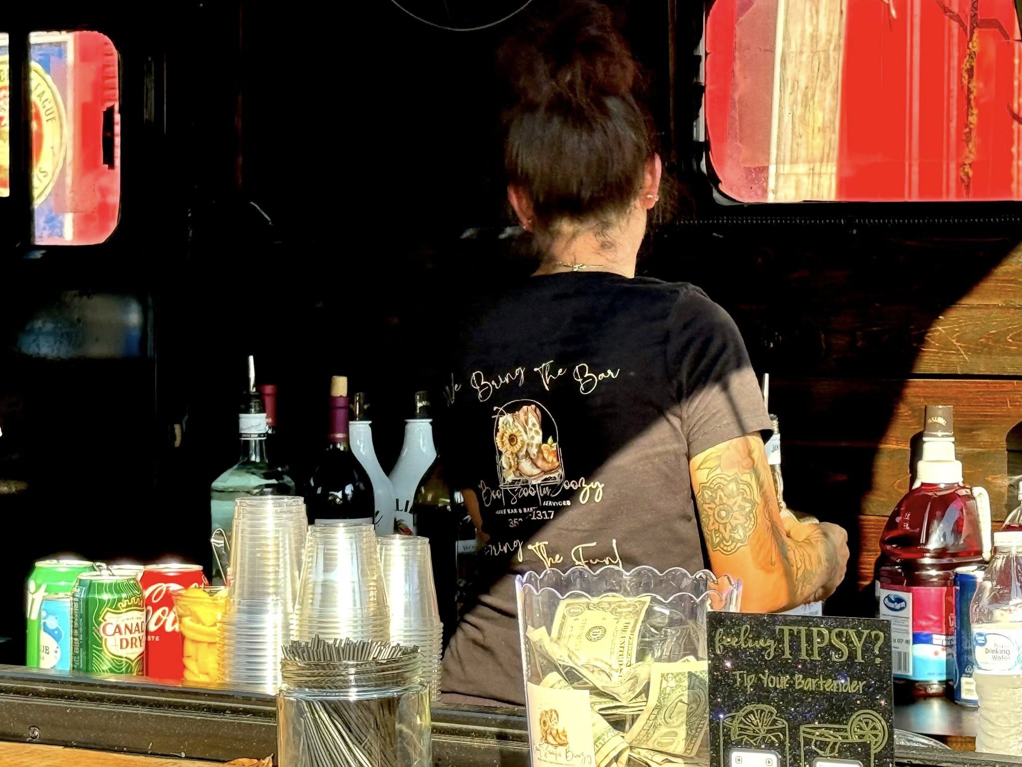 Bartender working inside the Boot Scootin' Boozy trailer bar